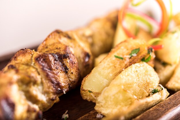 Pork skewers served with baked potatoes, Coleslaw salad and barbecue sauce