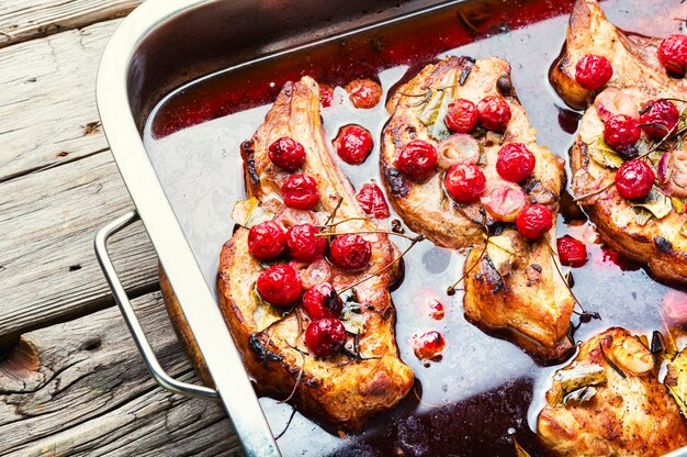 Pork steak on the bone roast in berry marinate.Meat in cherry wine sauce