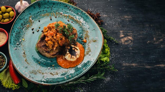 Pork steak grilled with zucchini caviar Meat Top view On a black wooden background Copy space