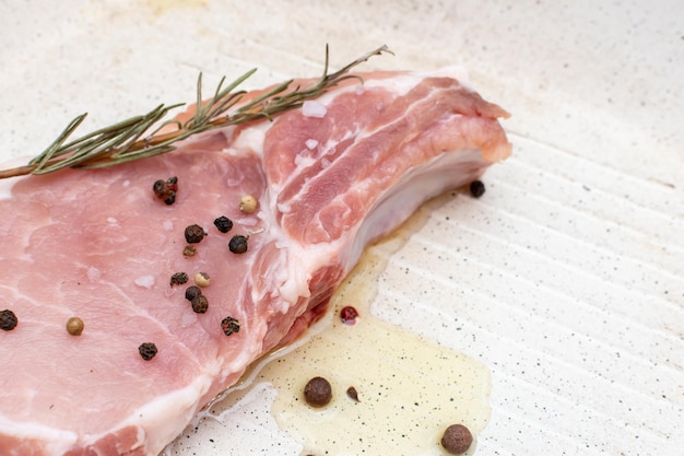 Photo pork steak with olive oil black pepper and rosemary