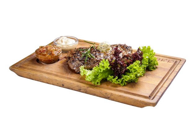 Pork steak with sauces and greens On whiteboard and white background