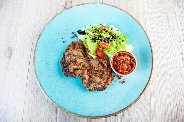 pork steak with tomato spicy sauce and salad