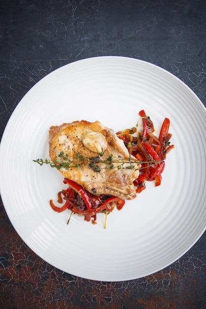 Pork steak with vegetables, Restaurant white plate on a dark background