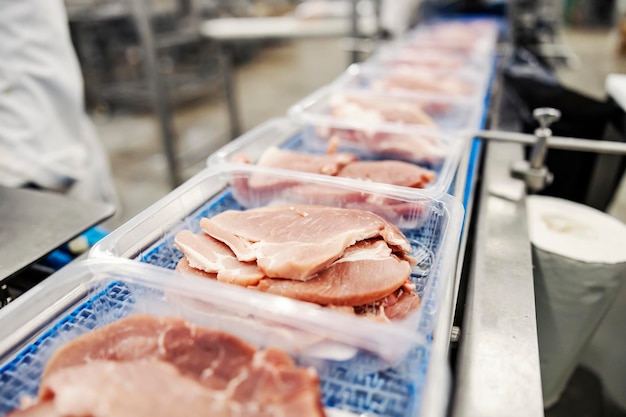 Pork steaks in package on conveyor in meat factory