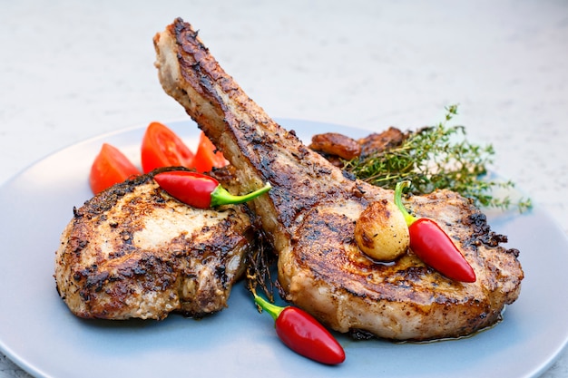 Pork steaks on a plate with chili, tomatoes