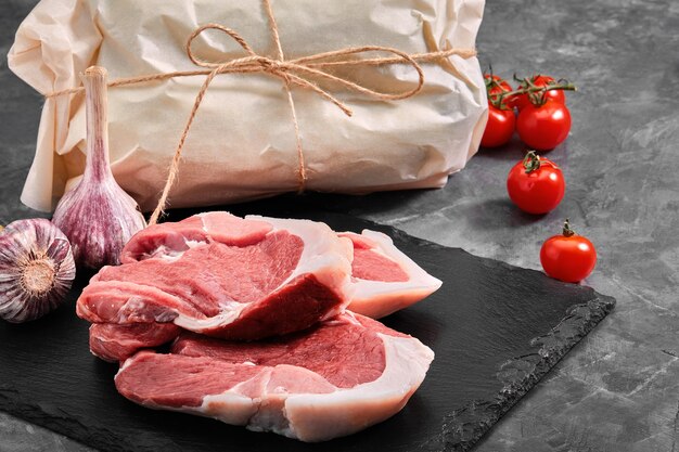 Pork tenderloin Two pieces of pork meat on a slate plate on a gray background copy space photo for grocery stores