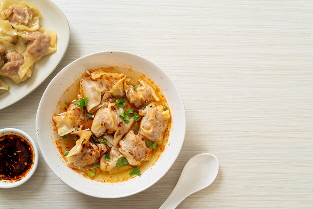 돼지 고기 완탕 수프 또는 구운 칠리를 곁들인 돼지 고기 만두 수프-아시아 음식 스타일