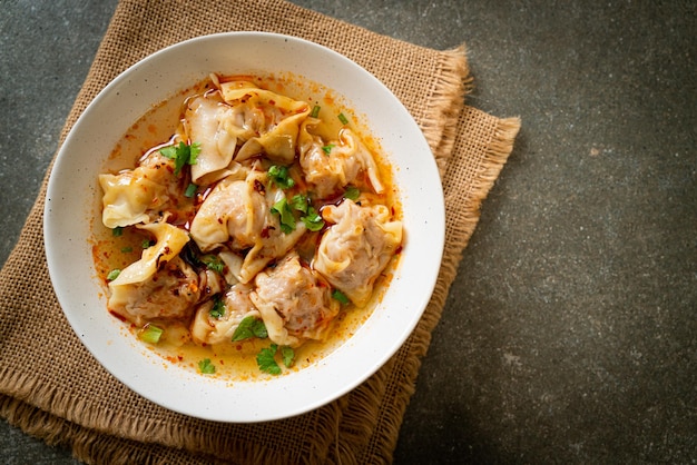 Zuppa di wonton di maiale o zuppa di gnocchi di maiale con peperoncino arrosto - stile asiatico