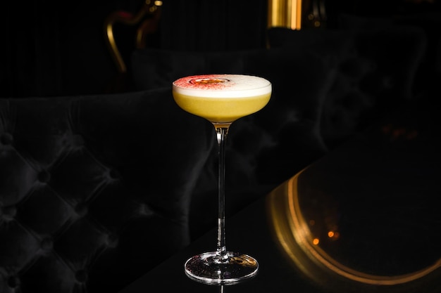 Pornoster martini-cocktail met passievrucht en wodka aan de bar in een donkere sfeer