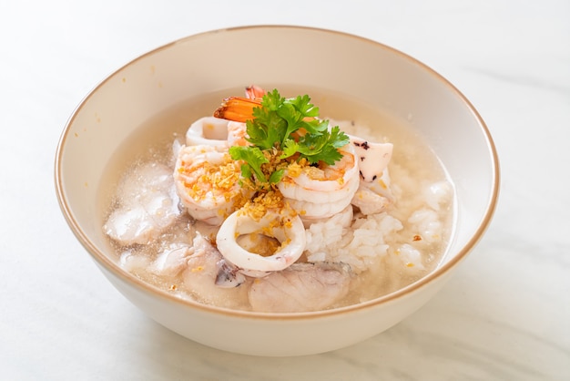 porridge or boiled rice soup with seafood (shrimps, squid and fish) bowl