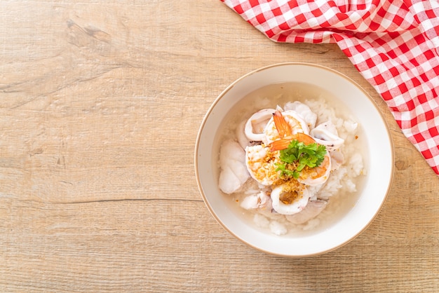 porridge or boiled rice soup with seafood (shrimps, squid and fish) bowl