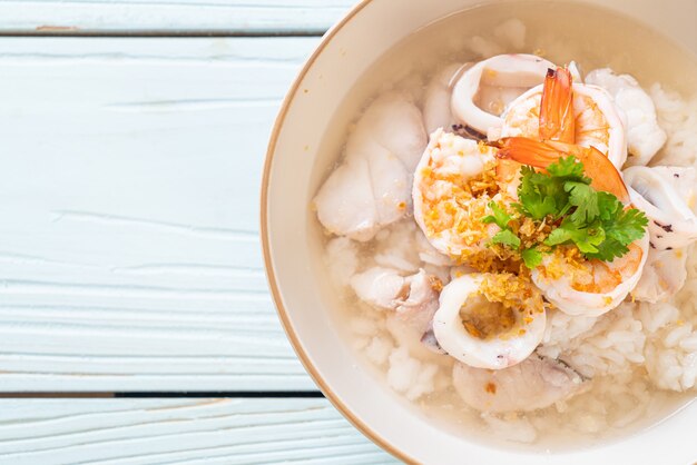 porridge or boiled rice soup with seafood (shrimps, squid and fish) bowl