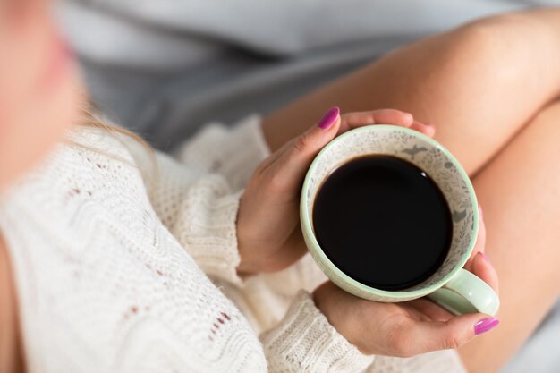 Foto porselein koffiebeker vastgehouden door de handen van een vrouw