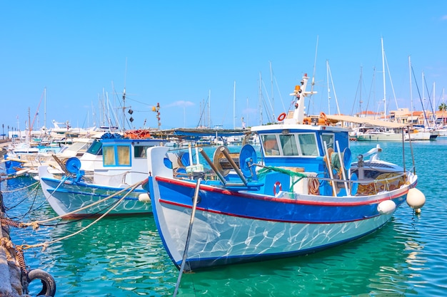 Port of Aegina and old white blue fishing boats on sunny day, Saronic Islands, Greece