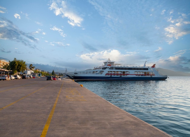 Port with ferryboat at sunset in a spa resort Loutra Edipsou on Greek island of Evia in Greece