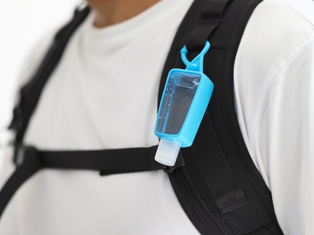 Portable hand sanitizer gel hanging on backpack.