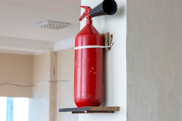 Portable handheld fire extinguisher mounted on the wall inside the room