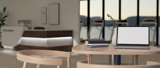 Portable laptop mockup and decor on table over blurred background of modern fitness reception