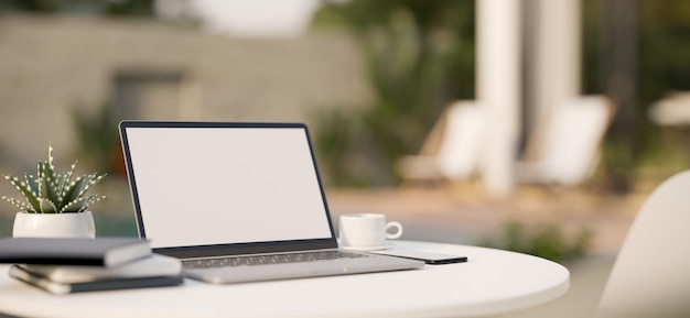 A portable outdoor workplace with laptop on outdoor lounge table beside swimming pool