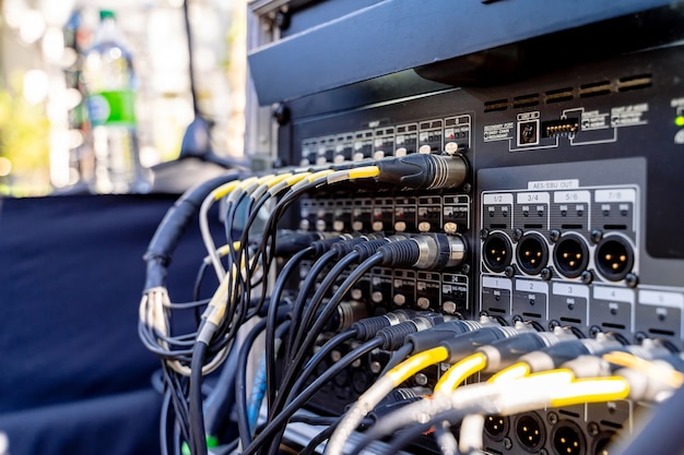 Portable pa systems. cables plugged in the inputs of mixing\
console of a sound engineer. closeup.