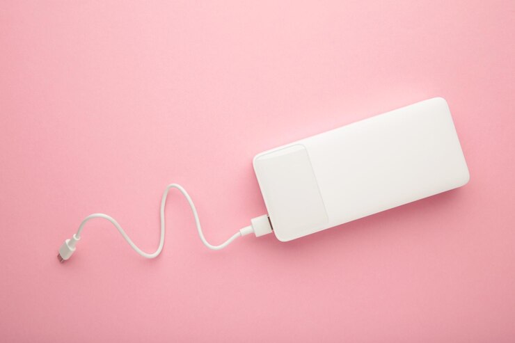 ピンクの背景にUSBケーブル付きのポータブルパワーバンク