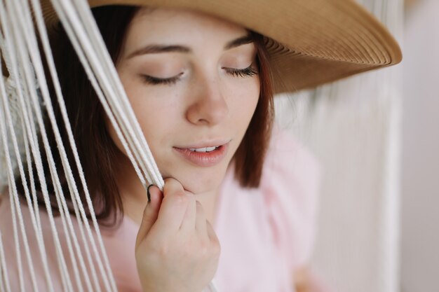 夏の帽子をかぶっている美しい若い笑顔の女性の肖像