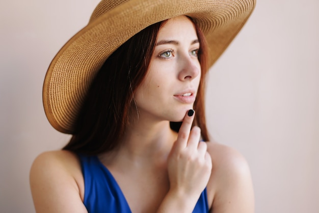 portait of a beautiful young smiling woman wearing summer hat