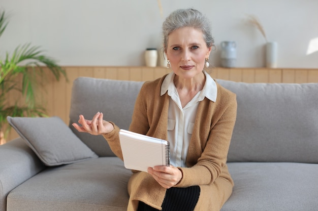 Portait of smiling beautiful middle aged woman looking at camera, making video call, job interview or online dating.