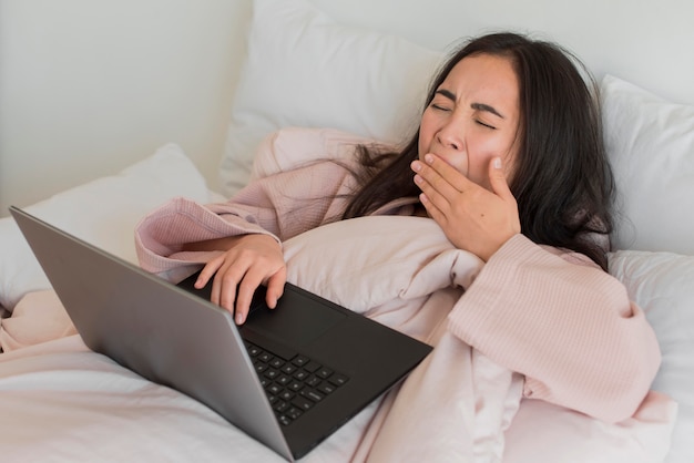 Photo portait woman on bed with laptop