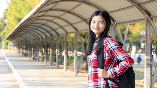 Foto portarit studentessa felice ragazza con uno zaino a scuola