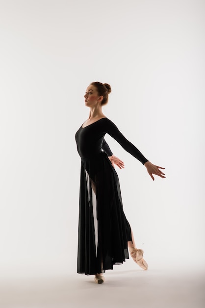 Portarit van sensuele professionele Kaukasische callet-danser in pak en pointes-schoenen op wit.