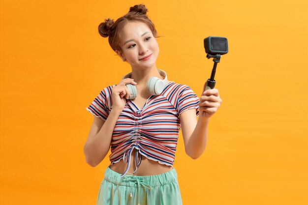 Porter of woman with short black hair holding a camera with one hand