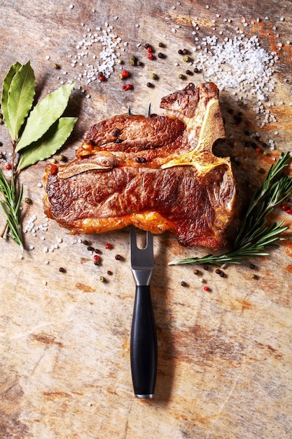 Porterhouse steak is speared with carving fork