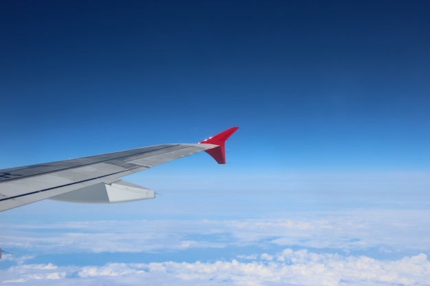 porthole view of the airplane wing and sky