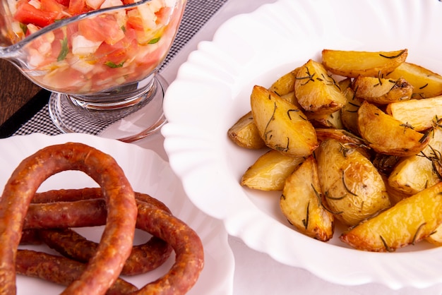 Portie geroosterde aardappelen en worst en vinaigrette