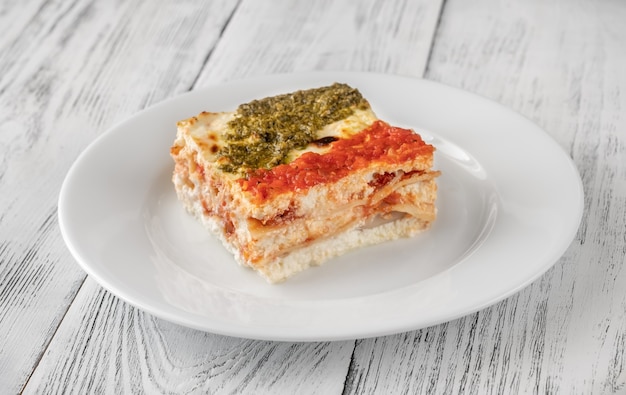 Portie ricotta lasagne overgoten met tomatensaus en pesto