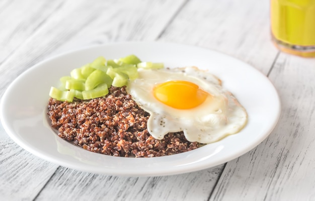 Portie rode quinoa met gebakken ei en selderij