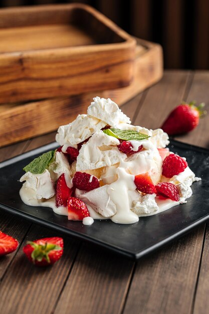 Portion of airy pavlov dessert with red berries