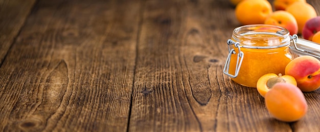 Photo portion of apricot jam on wooden background selective focus