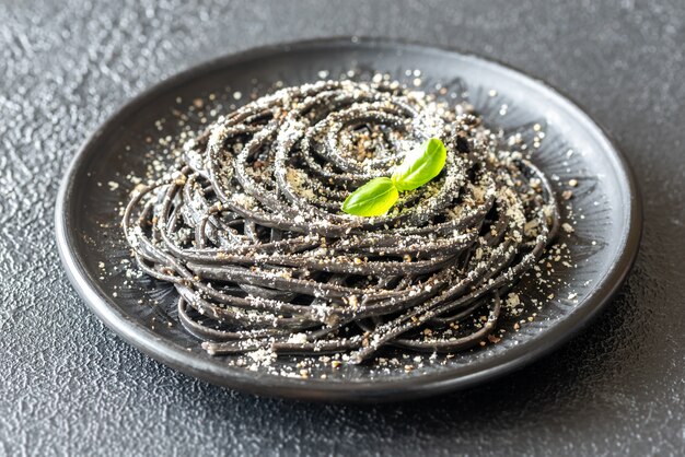 Portion of black Cacio e pepe pasta