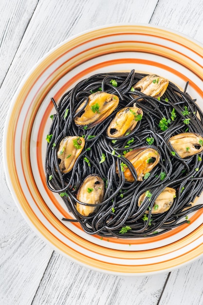 Portion of black spaghetti pasta with mussels