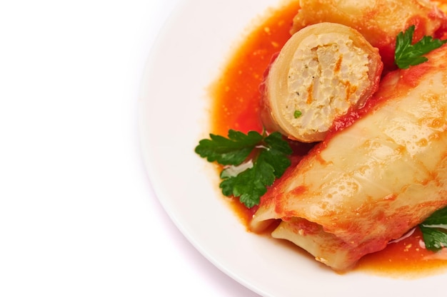 Portion of cabbage rolls stuffed with ground beef and rice with sour cream on a plate