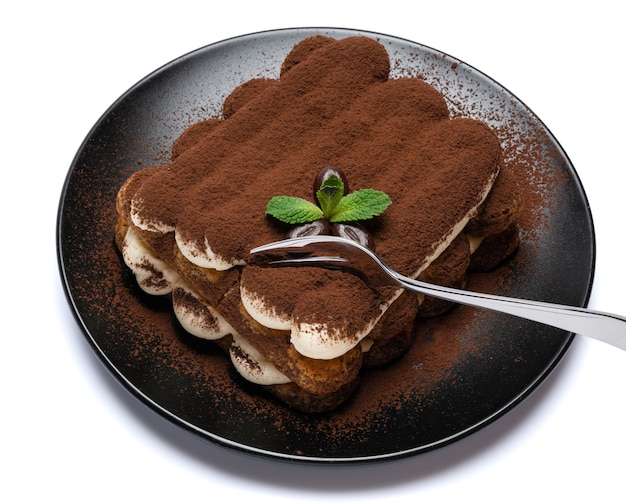 Portion of Classic tiramisu dessert on ceramic plate isolated on white background