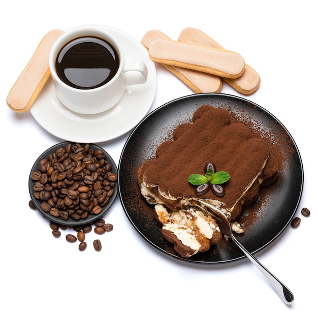 Portion of Classic tiramisu dessert, savoiardi cookies and cup of fresh espresso coffee isolated on white background