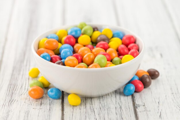 Portion of Cocolate coated Peanuts on wooden background selective focus