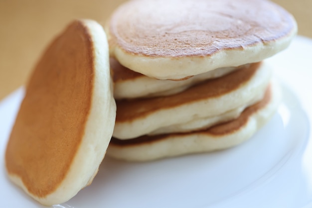 Portion of cooked flour pancakes lying on white plate closeup