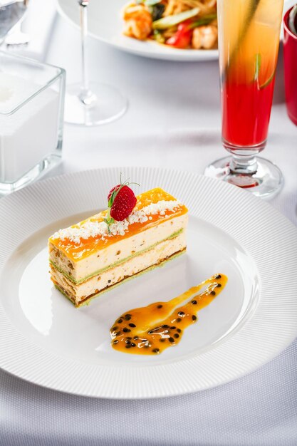 Foto porzione di torta mousse di dessert con pistacchi e frutti tropicali al frutto della passione