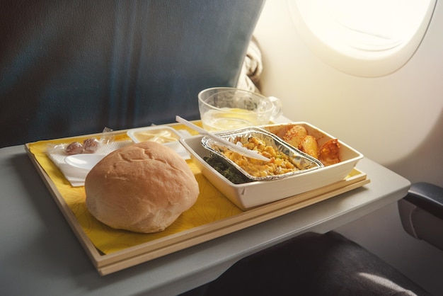 Portion of food for one passenger in cardboard box at airplane board