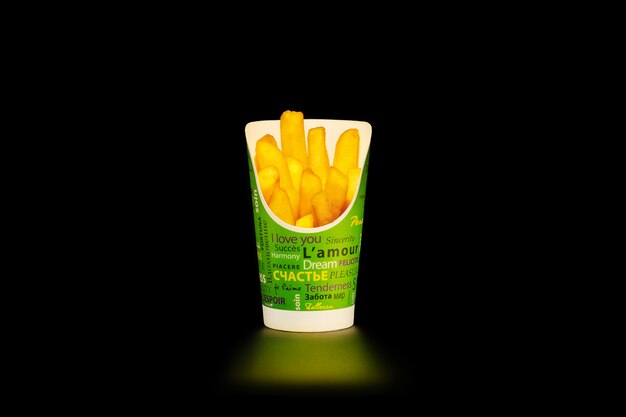 A portion of French fries in a cardboard Cup with inscriptions in different languages