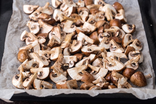 A portion of fresh chopped mushrooms on a baking sheet before baking.